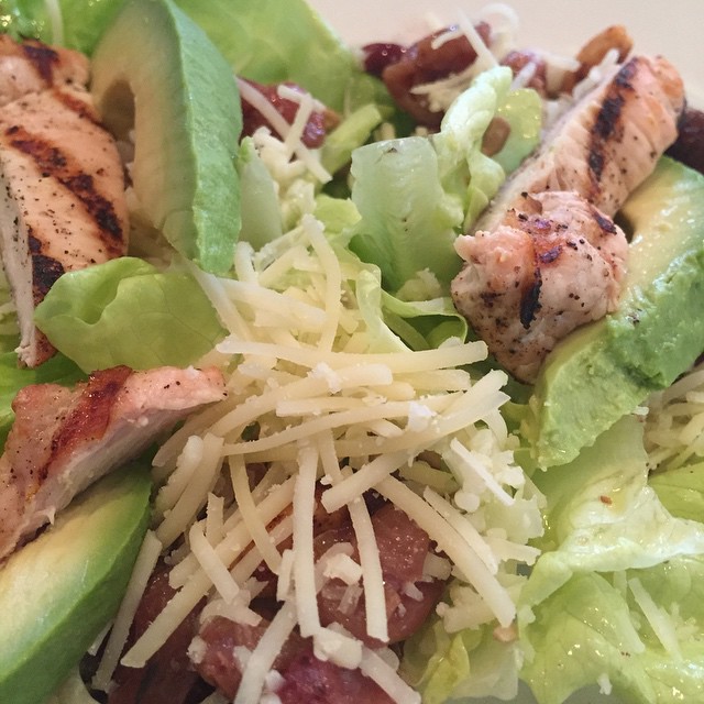 Close-up of a colorful salad with grilled chicken, avocado, and greens